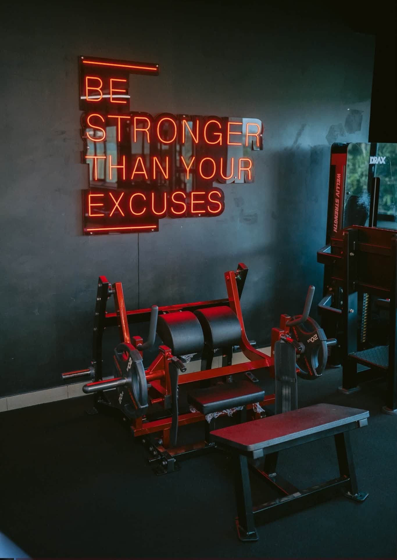 Neon sign reading 'be stronger than your excuses'
